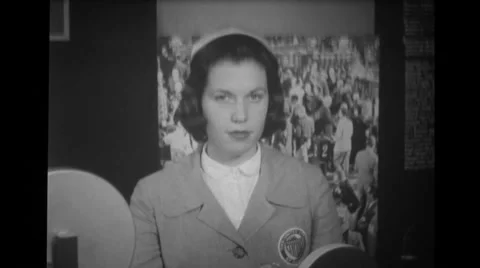 Woman at counter speaking in microphone while audience and sailors watch her Stock Footage