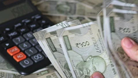 Woman Counting Indian Rupee Notes with Calculator Stock Footage 344051906