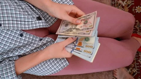 Woman counting a large stack of us dollar bills Stock Footage 329472674