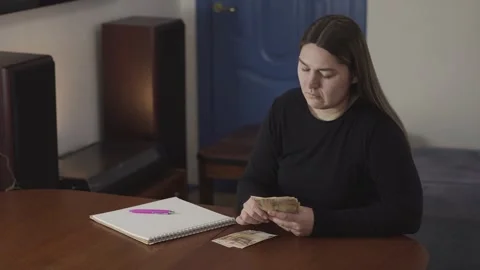 Woman Counting Money at Table While Worrying About Bills and Personal Problems Stock Footage 334122135