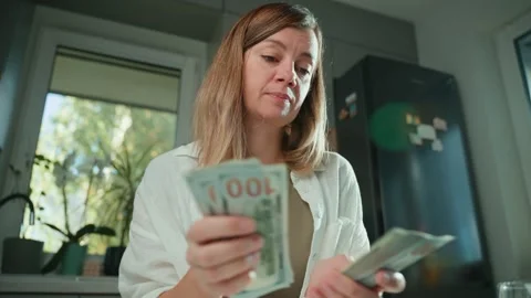 Woman counting stack of dollar bills at home Stock Footage 290298825
