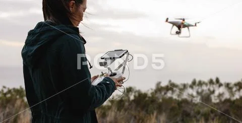 Woman in countryside flying drone and taking pictures Stock Photos