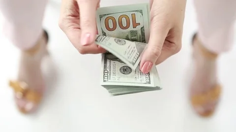 A woman counts a pack of dollars.  Stock Footage 76581938
