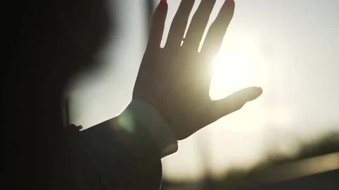 Woman covers the rays of the setting sun with her palm. Stock Footage 251009456
