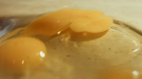 Woman cracking raw egg with knife above a bowl. Process of preparing pancakes Stock Footage 239024097