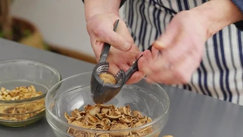 Woman cracking walnuts with a nut cracker Stock Footage 84177165