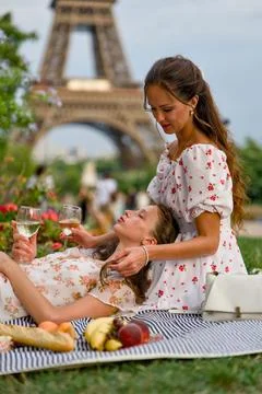 Woman Cradling Friend at Eiffel Tower Wine Picnic Stock Photos