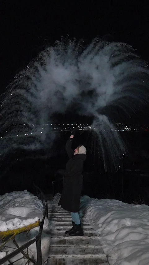 Woman creating ice cloud with hot water at night Stock Footage 337561037