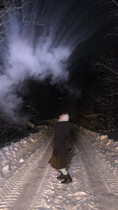 Woman creating ice cloud with hot water at night Stock Footage 337642769
