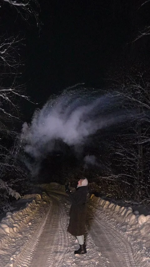 Woman creating ice cloud with hot water at night Stock Footage 337883627