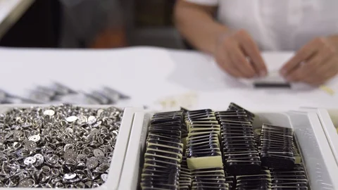 Woman creating personalized pins at table. Boxes with button and badge parts. Stock Footage 101258657