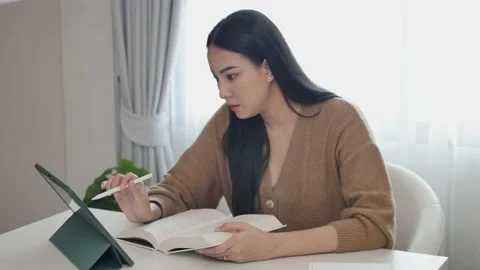 A woman creator is taking notes in a notebook working in front of her house  Stock Footage 197481137