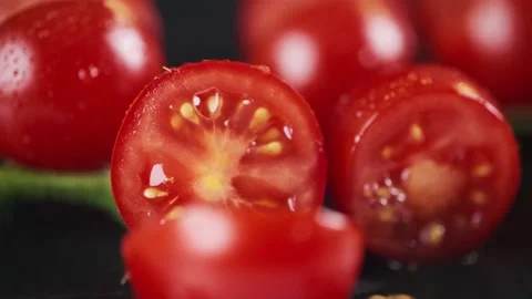 Woman crushes a fresh cherry tomato with a knife. Cooker preparing vegetarian Stock Footage 229642592