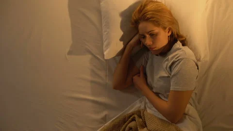 Woman crying touching empty side of bed, loss of beloved, depression, top view Stock Footage 106228598