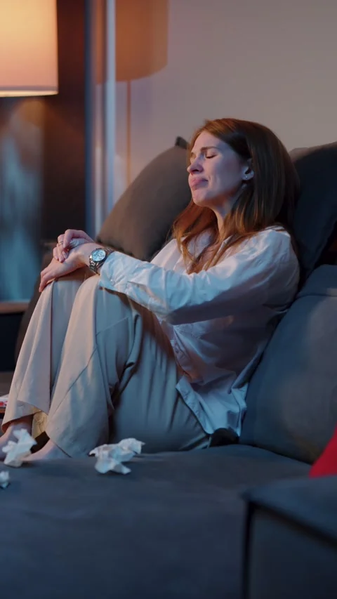 Woman crying while watching TV on sofa 스톡 동영상 323186751