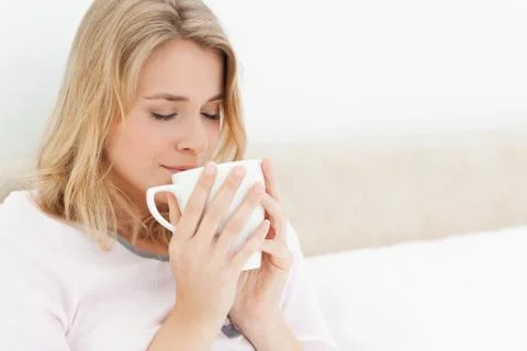 Woman with a cup rasied to her face eyes closed taking in the aroma Stock Photos