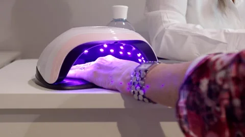 Woman Curing Gel Nails Under Glowing UV Lamp, Beauty Salon, Close Up Shot Vídeo Stock 341306609
