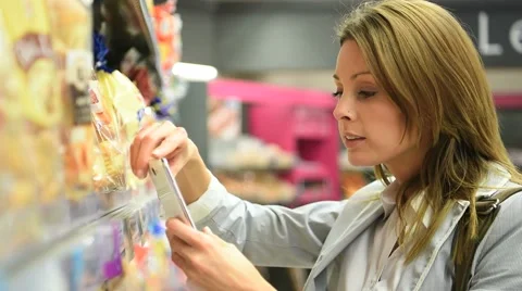 Woman customer scanning food products in grocery store Stock Footage