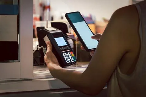 Woman customer scanning QR code on terminal payment to pay bill with smart .. Photos