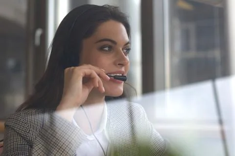Woman customer support operator with headset and smiling. Stock Photos