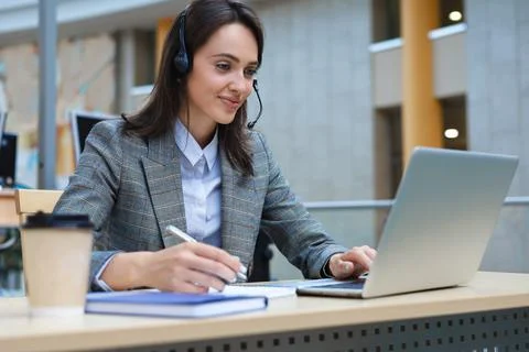 Woman customer support operator with headset and smiling. Stock Photos