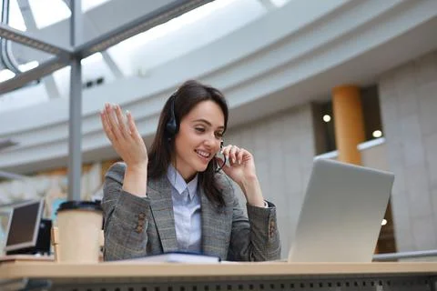 Woman customer support operator with headset and smiling. Stock Photos