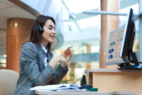 Woman customer support operator with headset and smiling. Stock Photos