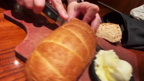A Woman Cuts into Bread at Restaurant for Appetizer Stock-Footage 342368868