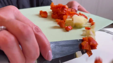 A woman cuts up cooked vegetables for making olivier salad Stockbeeldmateriaal 301874049