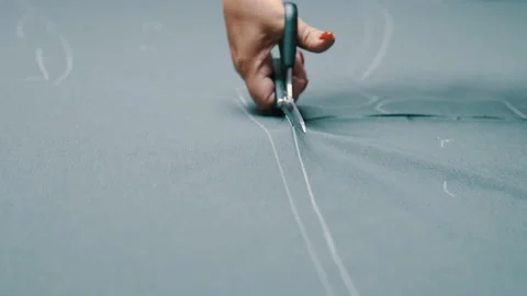 Woman cuts dark fabric with scissors Stock Footage 140436282