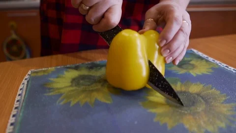 A woman cuts a large yellow pepper lengthwise. Cooking vegetables. Stock Footage 123724518