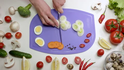 Woman cuts leeks with sharp knife on chopping board Stock Footage 230038541