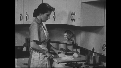 A woman cuts potato slices and places the pieces into pot full to the brim of Stock Footage