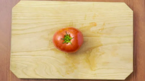 Woman cuts a tomato on a wooden board. view from above Stock Footage