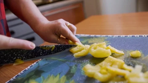 A woman cuts a yellow pepper on a cutting Board. Close up. Cooking. Stock Footage 123724766