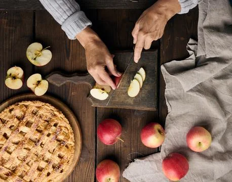 Woman cutting apples for pie on brown wooden table, top view Stock Photos