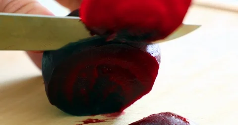 A woman cutting Beetroot vegetable on circles pieces with knife Stock Footage 88316843