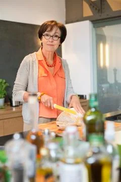 Woman cutting bread in the kitchen Stock Photos