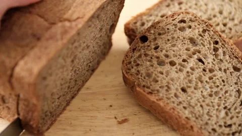 Woman cutting bread at the kitchen. Slicing bread to make a sandwich. Cooking Stock Footage 244515542