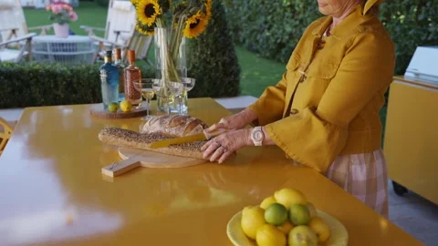 A woman is cutting bread on a yellow table Stock Footage 297870604