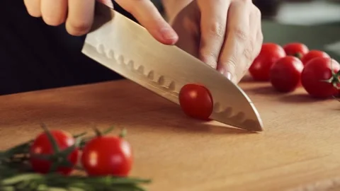 Woman cutting cherry tomatoes for salad. Female hands preparing cherry tomato Stock Footage 194661953