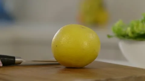 Woman cutting Grapefruit in half Stock Footage 22053998