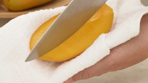 Woman cutting mango, preparing fruit salad Stock Footage 132559068