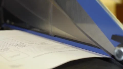 Woman cutting paper using handle cutter working in printing house. Video stock 257078638