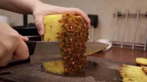 Woman cutting pineapple, using a knife for fresh and delicious tropical fruit Stock Footage 248817786