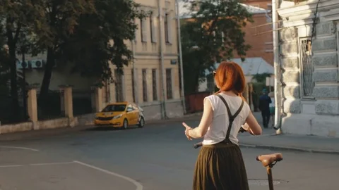 Woman cyclist walking beside riding bike on city road. Woman bike city Stock Footage