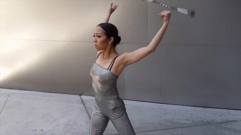 Woman dacing twirling baton intricate trick Stock Footage