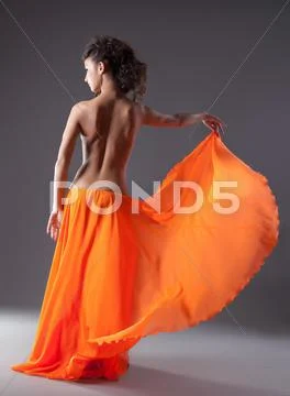 Woman dance in orange veil with naked spine Stock Photos