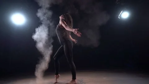 Woman dancer is making clouds of dust or powder by movement of hair, silhouette Vídeo Stock 143514268