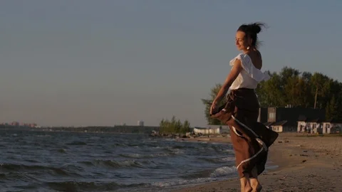 Woman dancing against the backdrop of the sunset sea. woman walking along the Vídeo Stock 104078301